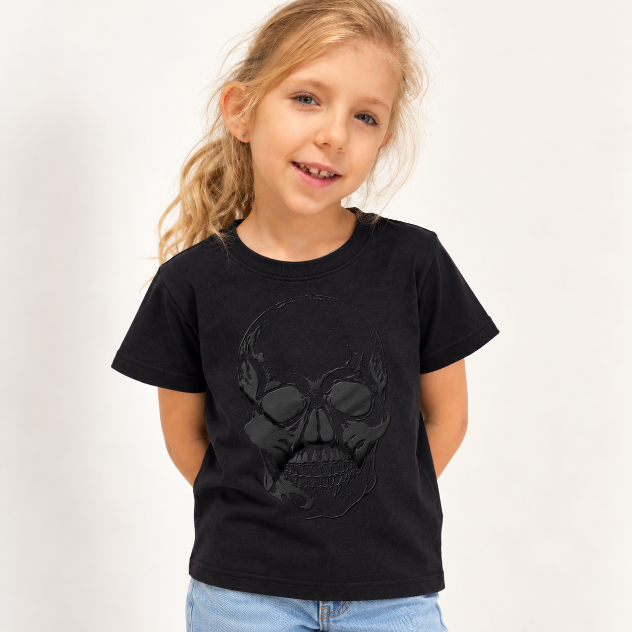 Dziewczynka w czarnym T-shircie Name It z wypukłym nadrukiem czaszki 3D – moda dziecięca ODKRYJTO
